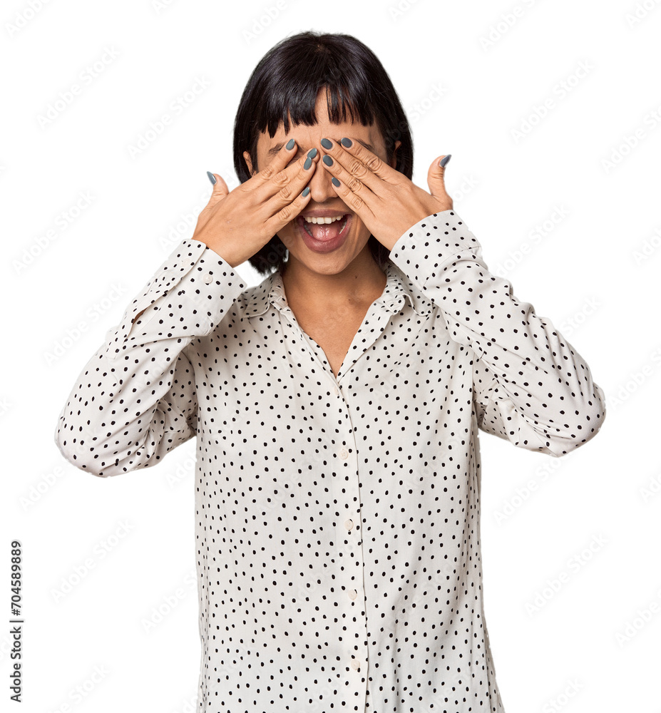 Young Hispanic woman with short black hair in studio covers eyes with hands, smiles broadly waiting for a surprise. Young Hispanic woman with short black hair in studio covers eyes with hands, smiles broadly waiting for a surprise.