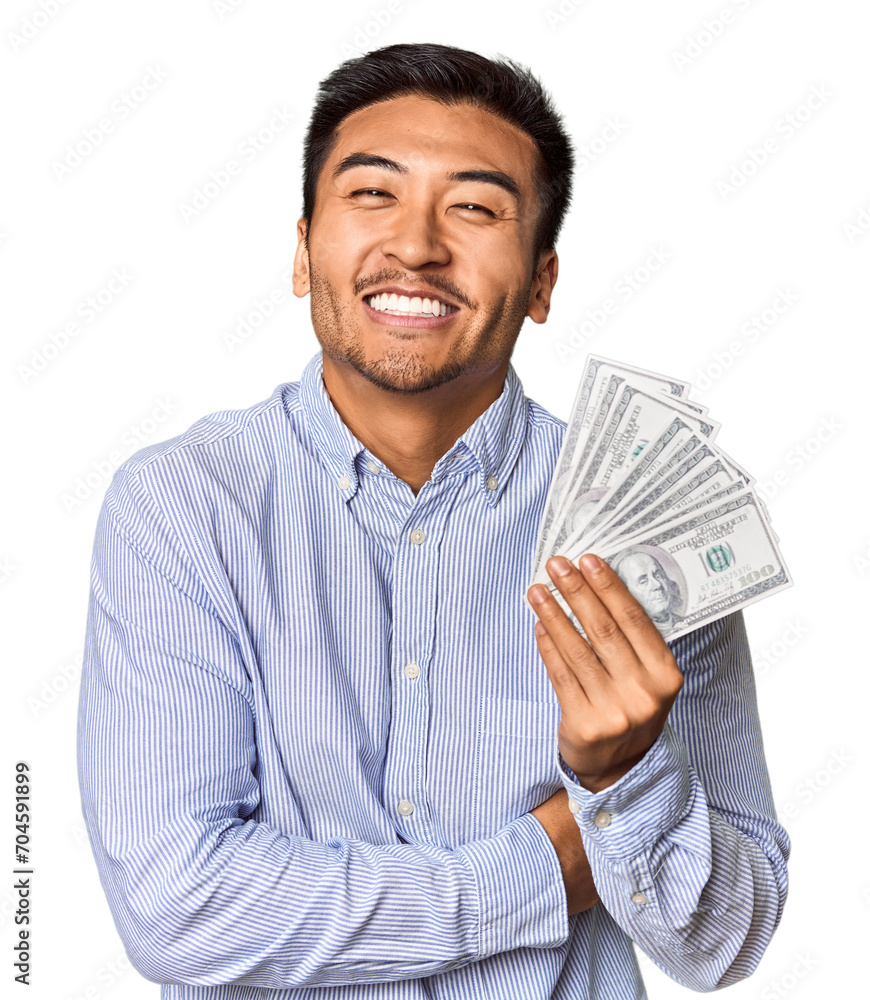 Young Chinese man holding dollar bills in studio laughing and having fun. Young Chinese man holding dollar bills in studio laughing and having fun.