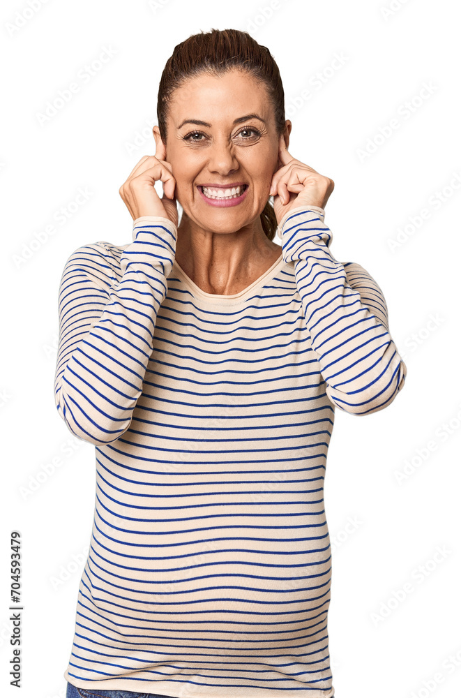 Pregnant middle-aged woman in studio setting covering ears with hands. Pregnant middle-aged woman in studio setting covering ears with hands.