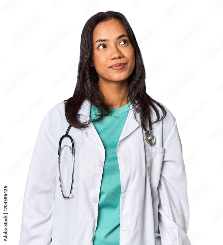 Young Filipina doctor with stethoscope in studio dreaming of achieving goals and purposes Young Filipina doctor with stethoscope in studio dreaming of achieving goals and purposes