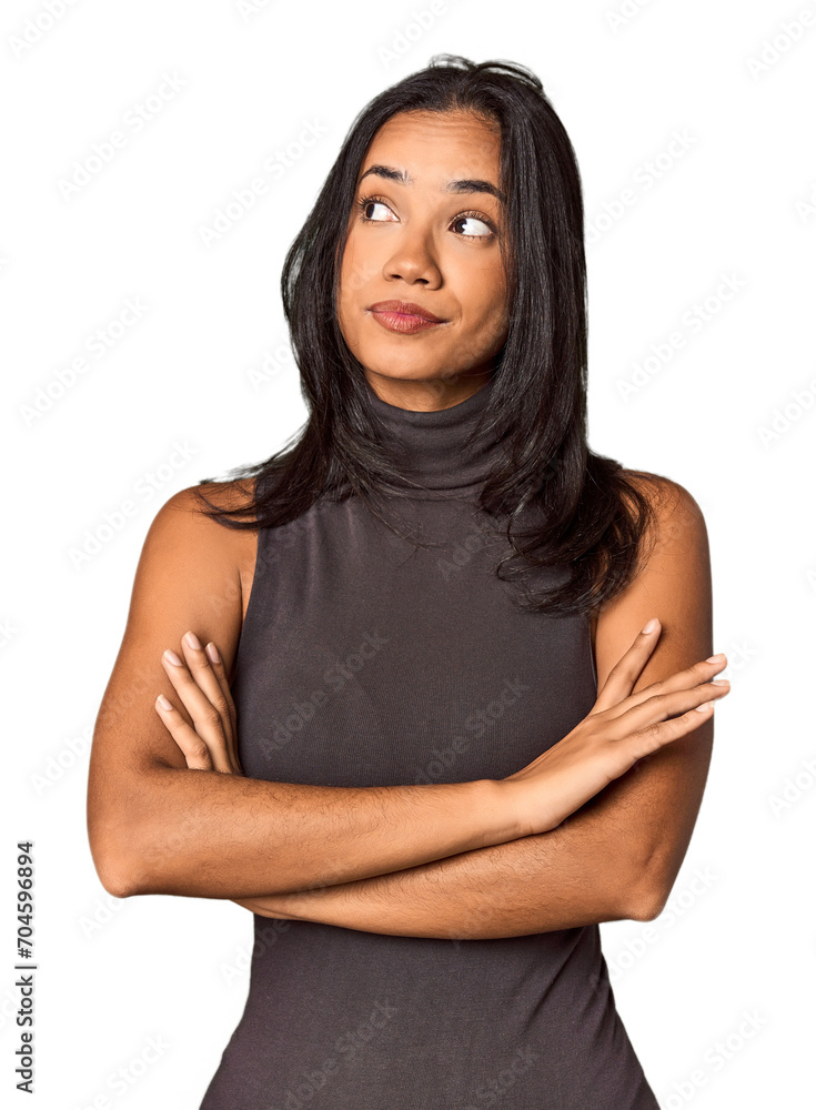 Fototapeta premium Young Filipina with long black hair in studio dreaming of achieving goals and purposes