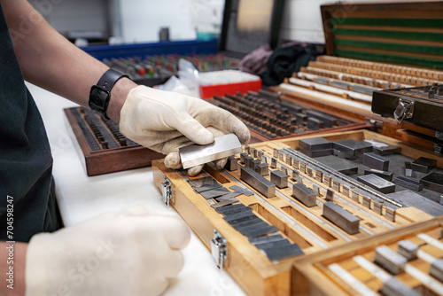 The worker selects gauge blocks to obtain the required control size of the part being manufactured and adjusts the measuring tool of a CNC metal-cutting machine. photo
