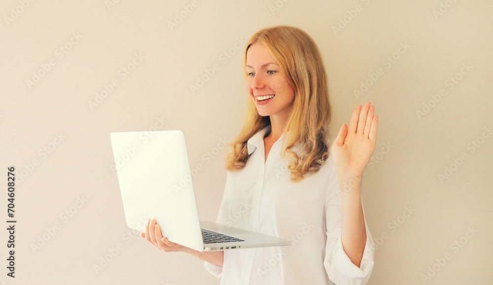 Happy smiling caucasian young woman greets communicates with friends via video call on laptop at home Happy smiling caucasian young woman greets communicates with friends via video call on laptop at home