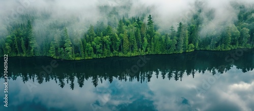 Cloudy reflections of forest-surrounded lake in Northern Ontario captured from above. photo
