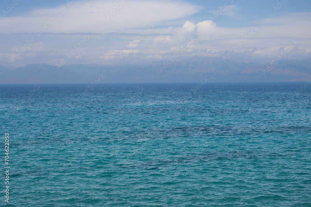 Obraz premium Ionian sea and a cloudy sky above mountains, Corfu, Greece