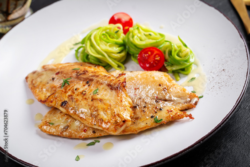 Grilled fish fillet with zucchini pasta. Healthy food concept.