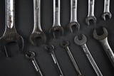Various type of hand tools such as open, ring and ratchet spanner, wrench, sockets, and deep sockets isolated on dark grey background with dramatic low-key lighting.