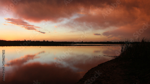 Las luces del ocaso siguen pintando las nubes reflejadas en el agua dulce de los ríos sudamericanos.