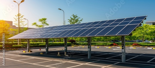 Photovoltaic technology used in urban infrastructure for electric vehicle charging, with solar panels on stand frame near parking lot.