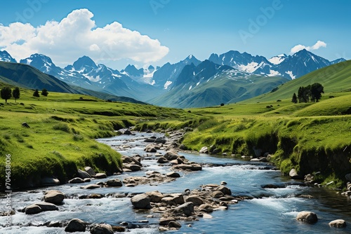 Alpine valley with river and snow capped mountains in distance
