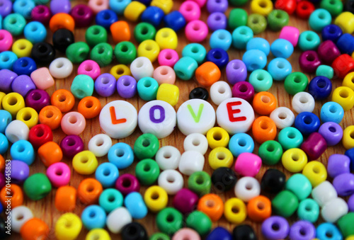 Word love among many colorful beads used to make necklaces and bracelets