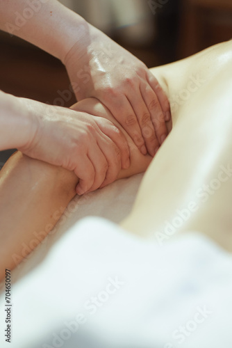 Massage therapist in massage cabinet massaging clients arm