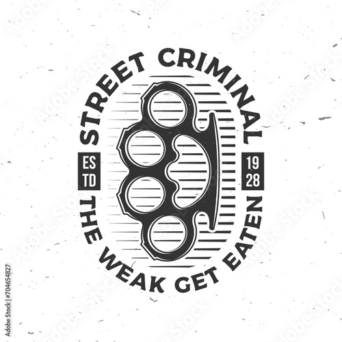 The weak get eaten. Classic gangster badge design. Vector illustration. Vintage monochrome label, sticker, patch with knuckle duster silhouette.
