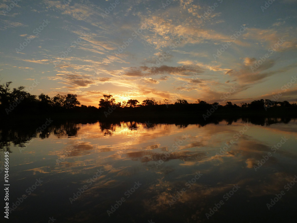 El rio de las islas santafesinas de America del Sur se trasforma en un espejo cuando cae el sol acompañado de nubes de colores.