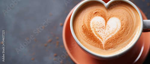 Cup of coffee with heart shape latte art on dark background.
