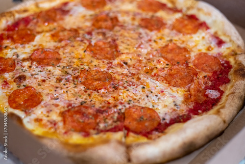 Large pizza cut into pieces, close-up. Selective focus