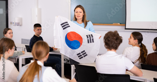 Young female professor shows students flag of South Korea