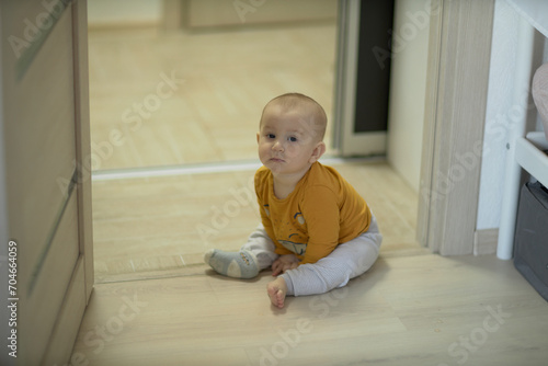 A baby is a happy baby in the first months of life, crawling around the house, smiling.