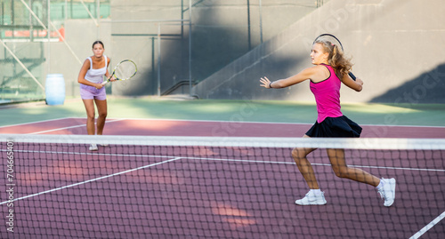 Caucasian woman wearing in pink t-shirt and skirt playing tennis match during training on court
