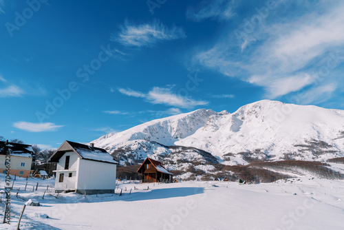Two-storey cottages in a mountain village at the foot of snow-capped mountains