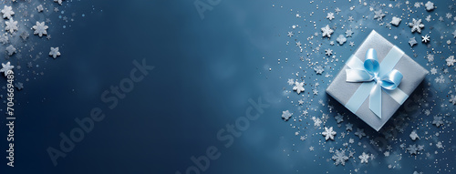 Silver gift box with blue ribbon on blue and snowflakes background. Top view. Banner with copy space for text. Generative AI.