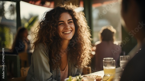 Curly-haired woman smiling at a restaurant