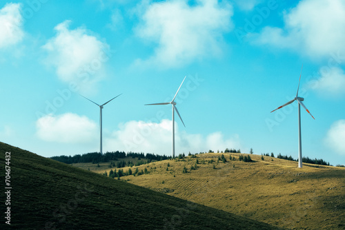 A wind farm or wind park at sunset located in the mountains of Italy Europe and it allows to realize clean energy. It’s sustainable, renewable energy for enviromental. Nature sky background positive