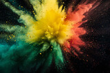 Colored powder explosion. Explosive splash red, yellow, green color powder dusk on black background. Black history month background