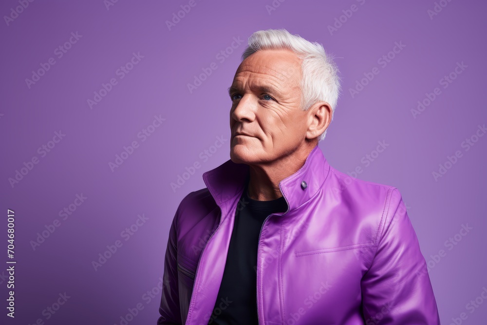 Serious mature man in a purple jacket. Portrait of a mature man in a purple jacket on a purple background.