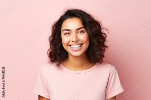 Portrait of a beautiful young woman smiling at camera over pink background