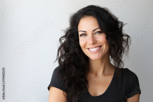 Portrait of happy smiling young beautiful brunette woman, over gray background © Iigo