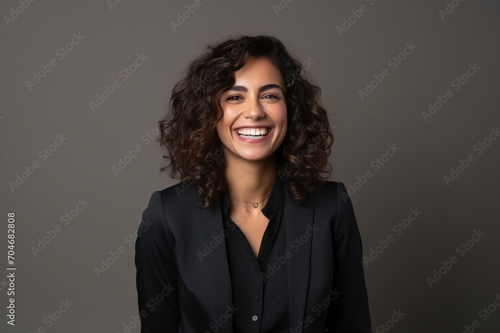 Portrait of a beautiful young business woman laughing against a grey background Portrait of a beautiful young business woman laughing against a grey background