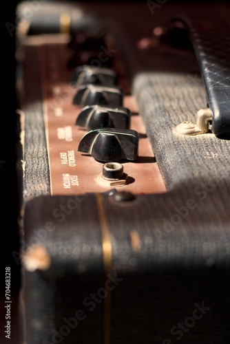 top view of an antique guitar amplifier, knobs and handle