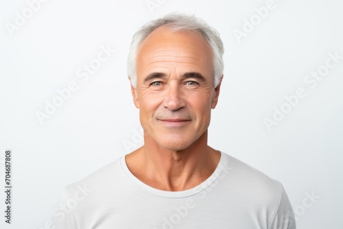 Portrait of a smiling senior man looking at camera on white background © Iigo