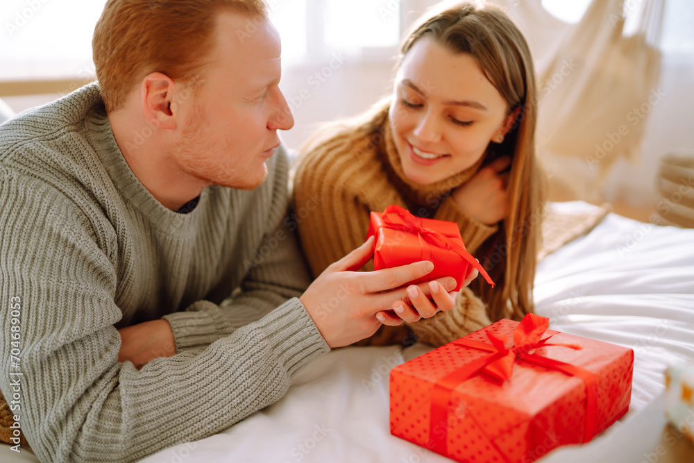 Couple in love on the bed spending time together. Man and woman relax and enjoy in bed at home. Concept of holiday, love, gifts. Couple in love on the bed spending time together. Man and woman relax and enjoy in bed at home. Concept of holiday, love, gifts.