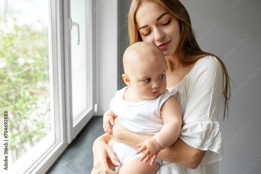 Mom carying of newborn baby at home. Childcare, maternity concept. Parent and little kid relaxing Mom carying of newborn baby at home. Childcare, maternity concept. Parent and little kid relaxing