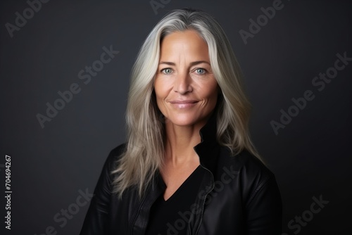 Portrait of a beautiful mature woman with grey hair on a dark background