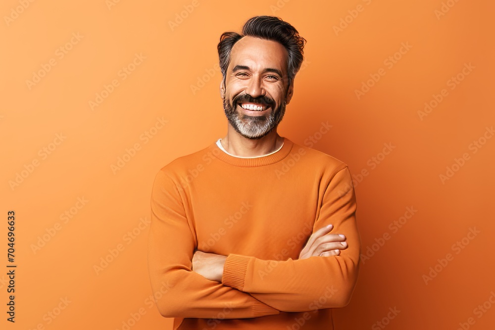 Portrait of a smiling middle-aged man in orange sweater on orange background