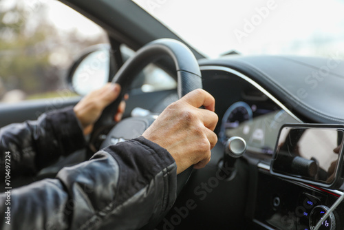hand gripping a steering wheel while driving a car, focused and in control