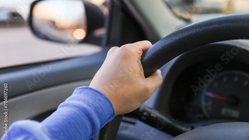 hand gripping a steering wheel while driving a car, focused and in control © Your Hand Please