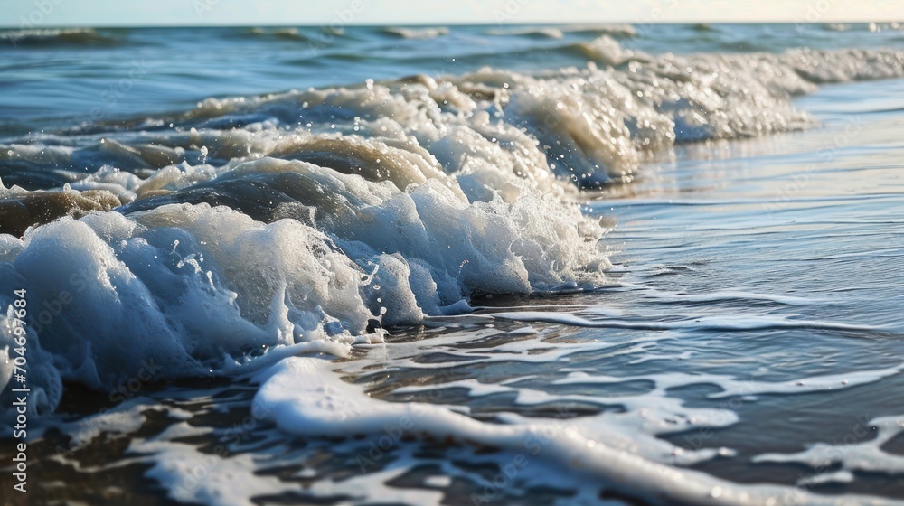 a close up of a wave coming in to the shore of a beach with foamy waves on the sand. a close up of a wave coming in to the shore of a beach with foamy waves on the sand.