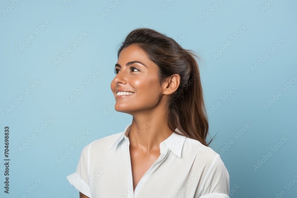 Portrait of happy smiling young woman in white shirt on blue background Portrait of happy smiling young woman in white shirt on blue background