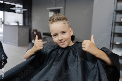 Young boy getting a haircut from a barber in a barbershop