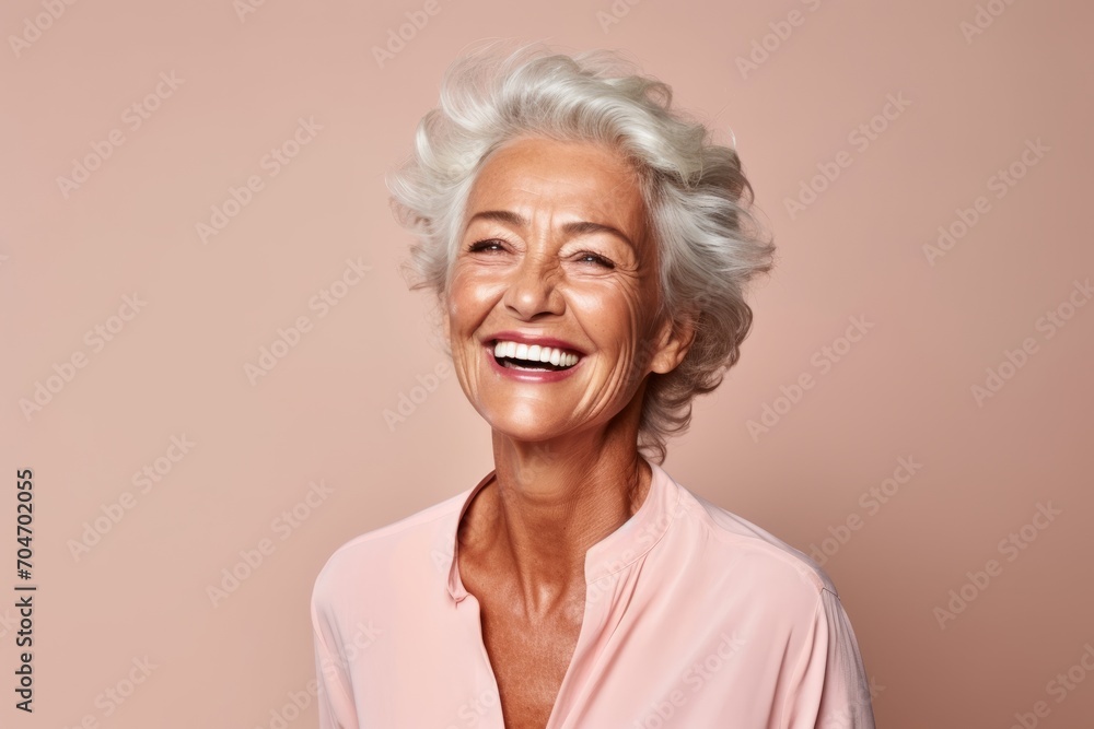 Portrait of a happy senior woman smiling at the camera on a pink background Portrait of a happy senior woman smiling at the camera on a pink background