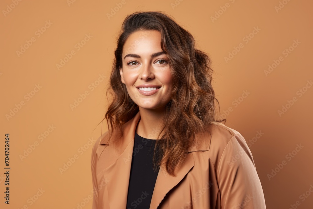 Portrait of smiling young woman in beige coat on brown background Portrait of smiling young woman in beige coat on brown background