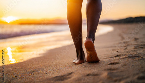 Closeup of woman's feet on sandy beach at sunset, evoking travel, relaxation, and summer vibes