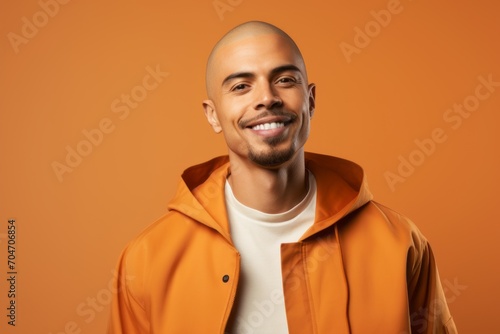 smiling african american bald man in orange jacket on orange photo
