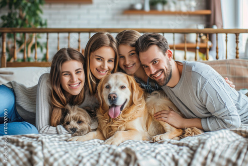 Group portrait of big family with kids and dogs lying on bed at home.