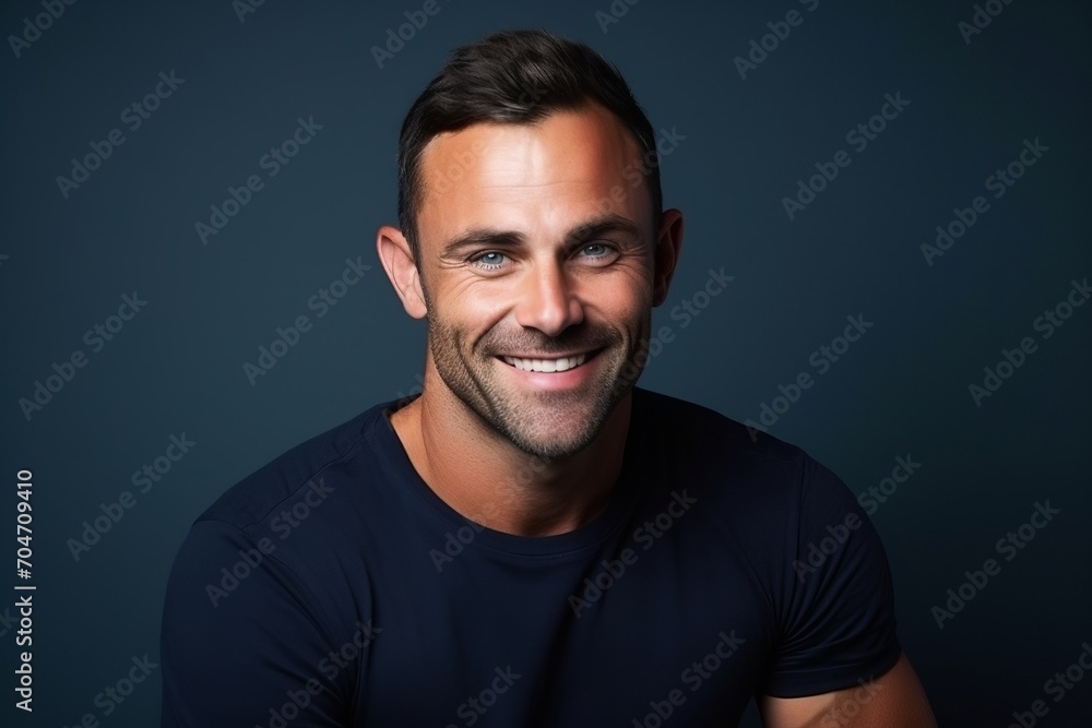 Portrait of a handsome man smiling at the camera, over dark background