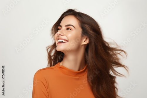Portrait of a happy young woman with long healthy brown hair on a white background